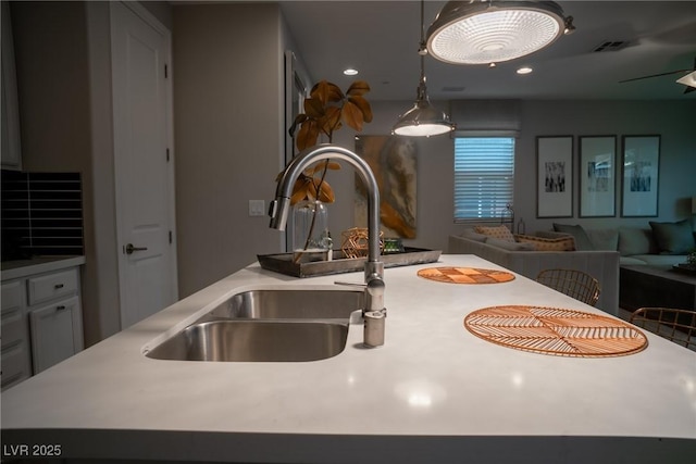 room details with a center island, sink, and decorative light fixtures