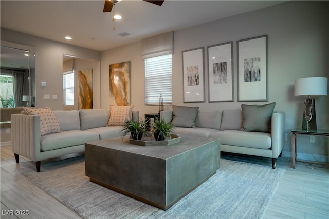 living room featuring hardwood / wood-style floors and ceiling fan