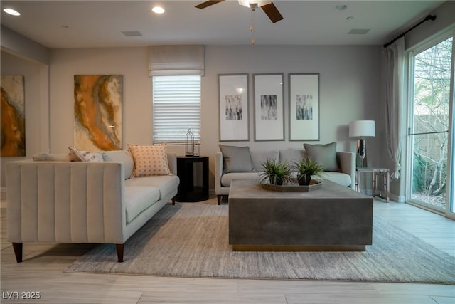 living room featuring ceiling fan and light hardwood / wood-style flooring