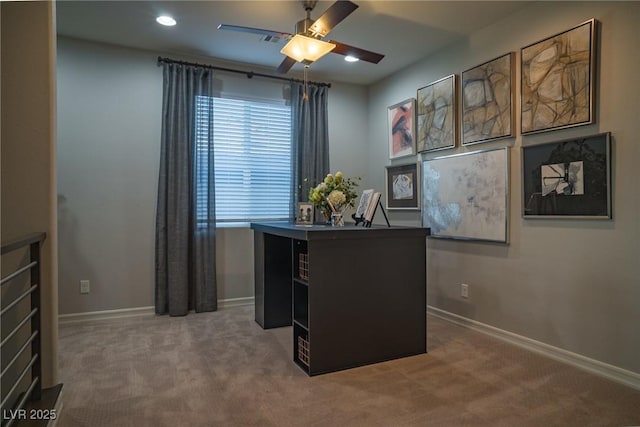 carpeted home office featuring ceiling fan