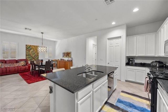 kitchen with sink, white cabinetry, hanging light fixtures, black appliances, and a center island with sink