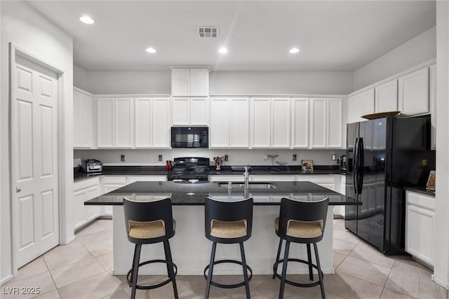 723 Orange Plume Walk Unit 0, Henderson, NV 89011 - kitchen with white cabinets, a sink, an island with sink, visible vents, and black appliances