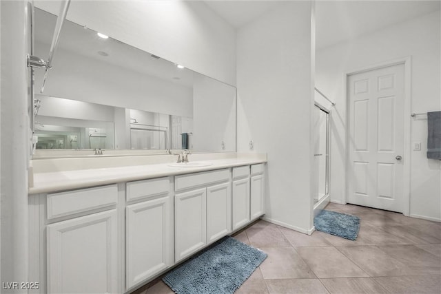 723 Orange Plume Walk Unit 0, Henderson, NV 89011 - bathroom with double vanity, tile patterned flooring, a stall shower, a sink, and baseboards