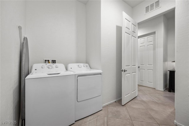 laundry room with independent washer and dryer and light tile patterned flooring