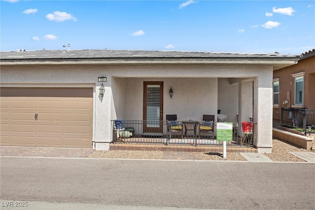 723 Orange Plume Walk Unit 0, Henderson, NV 89011 - view of front facade with a garage, roof mounted solar panels, and stucco siding