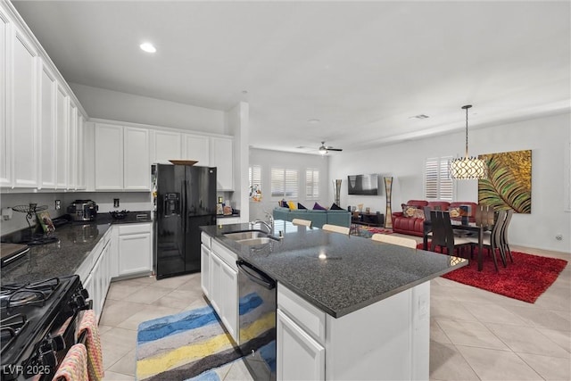 kitchen featuring sink, black appliances, an island with sink, pendant lighting, and white cabinets