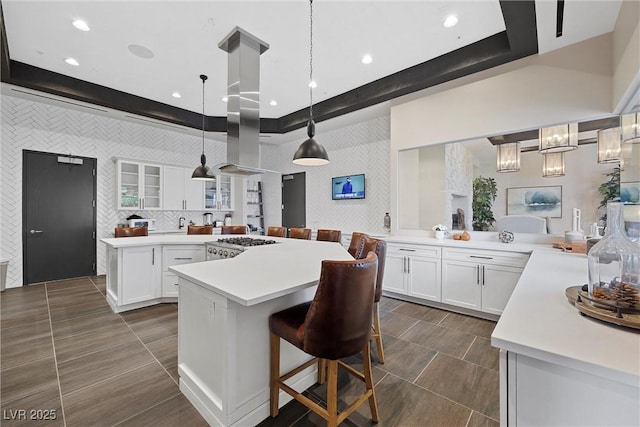 kitchen featuring white cabinetry, decorative light fixtures, a kitchen breakfast bar, and a center island