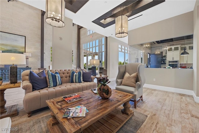 723 Orange Plume Walk Unit 0, Henderson, NV 89011 - living room with wood finished floors, baseboards, a high ceiling, and a chandelier