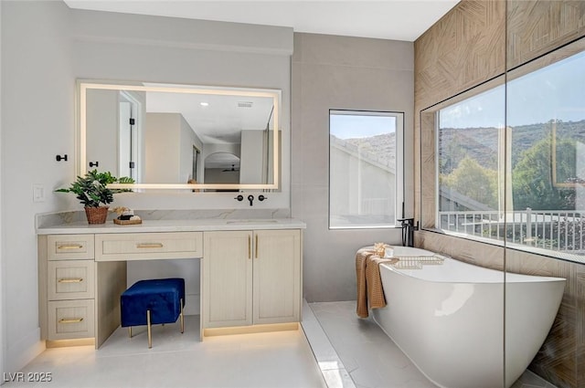 bathroom with vanity, a mountain view, and a bathtub