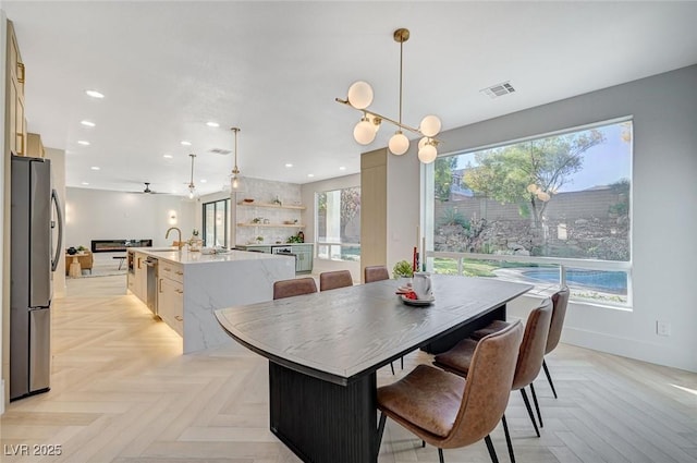 dining area with sink and light parquet floors