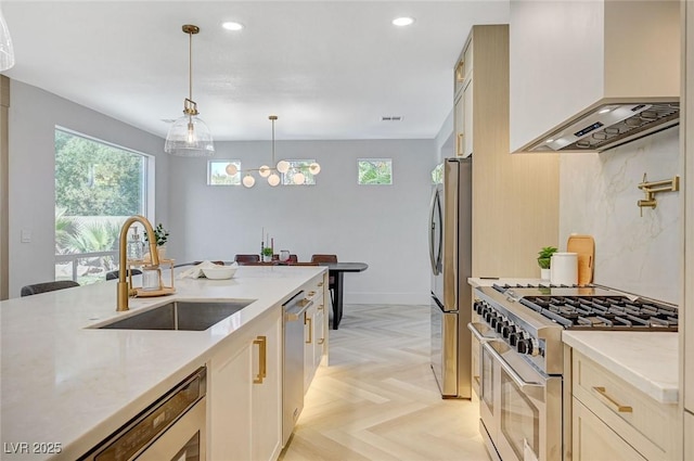 kitchen with sink, appliances with stainless steel finishes, hanging light fixtures, light stone countertops, and custom exhaust hood