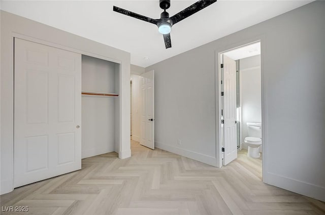 bedroom featuring light parquet flooring, ceiling fan, ensuite bath, and a closet