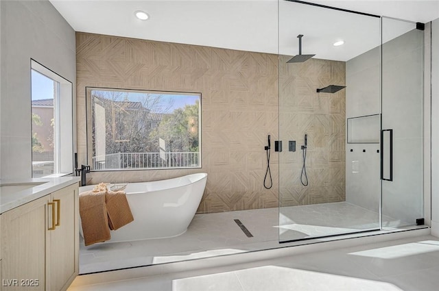 bathroom with vanity, separate shower and tub, and tile walls