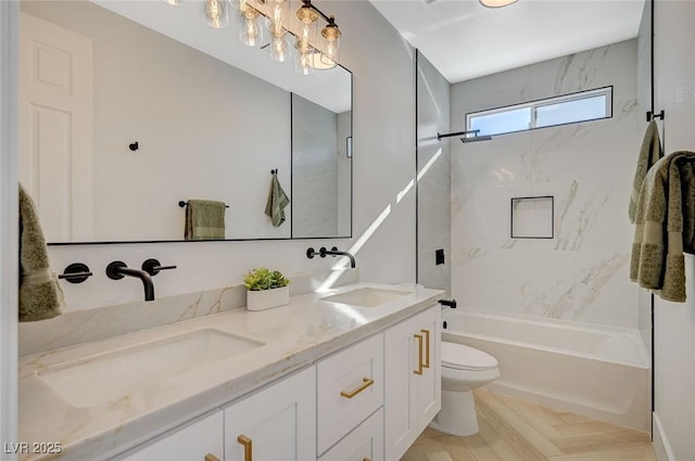 full bathroom featuring vanity, tiled shower / bath, and toilet