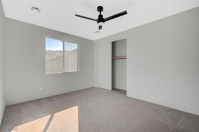 unfurnished bedroom with light colored carpet, ceiling fan, and a closet