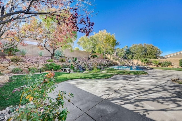 view of property's community with a fenced in pool and a patio