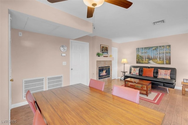 4861 S Torrey Pines Dr Unit 201, Las Vegas, NV 89103 - dining area with wood finished floors, ceiling fan, a tiled fireplace, and baseboards