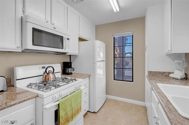 4861 S Torrey Pines Dr Unit 201, Las Vegas, NV 89103 - kitchen featuring white appliances, white cabinets, baseboards, and a sink