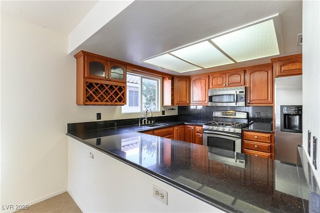 kitchen featuring dark stone countertops, sink, decorative backsplash, and stainless steel appliances