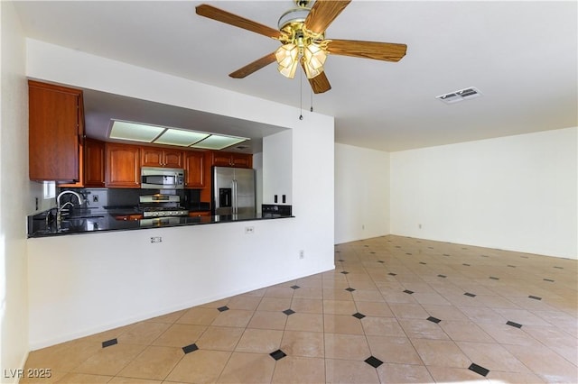 kitchen featuring stainless steel appliances, sink, light tile patterned floors, and ceiling fan