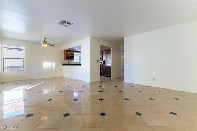 tiled spare room featuring ceiling fan