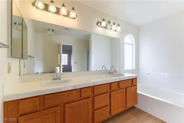 bathroom featuring vanity and a tub to relax in