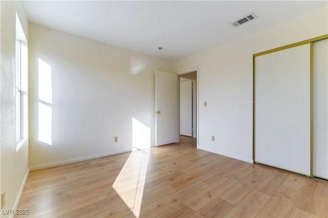 unfurnished bedroom with a closet and light wood-type flooring