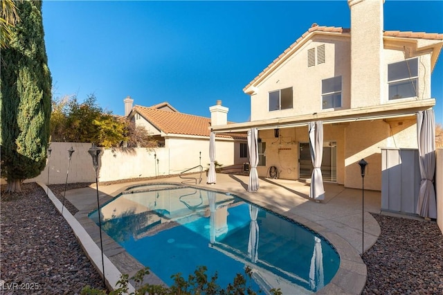 back of house featuring a fenced in pool and a patio