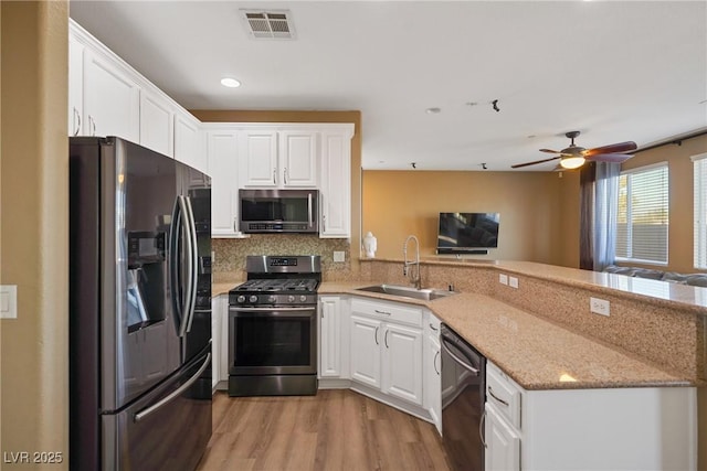 kitchen featuring stainless steel appliances, sink, and white cabinets