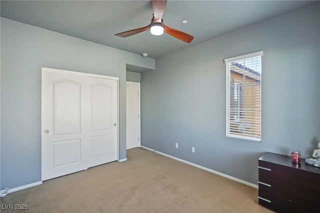 carpeted bedroom featuring ceiling fan and a closet