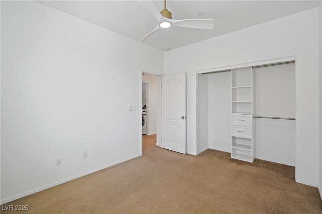 unfurnished bedroom with washer / clothes dryer, light colored carpet, a closet, and ceiling fan