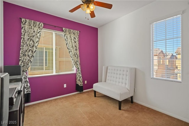 sitting room with ceiling fan and light colored carpet