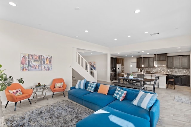 living room with stairs, visible vents, and recessed lighting