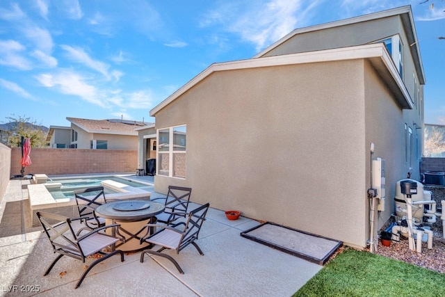 rear view of property featuring a patio area, a fenced backyard, a fenced in pool, and stucco siding