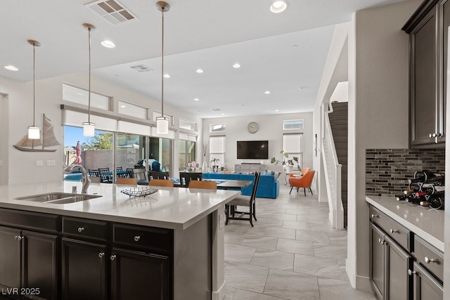 kitchen featuring visible vents, light countertops, a sink, and decorative light fixtures