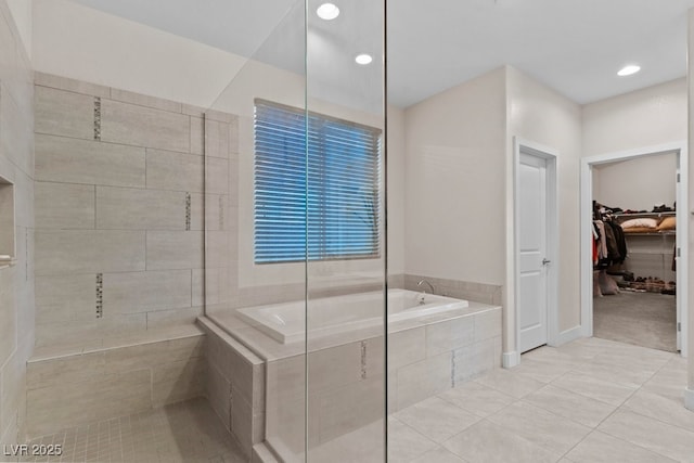 bathroom featuring a garden tub, recessed lighting, a walk in closet, and tile patterned floors