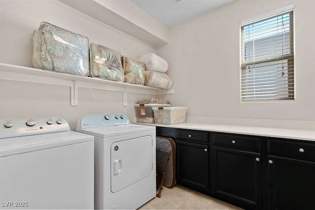 laundry room featuring washing machine and dryer, cabinet space, and light tile patterned floors