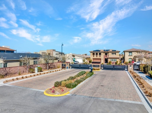 view of road featuring curbs, a gated entry, a gate, and a residential view