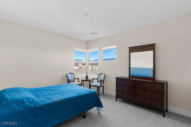 bedroom with baseboards, visible vents, and light colored carpet