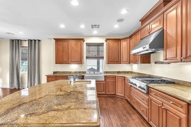 kitchen with dark hardwood / wood-style flooring, light stone countertops, stainless steel gas cooktop, and exhaust hood