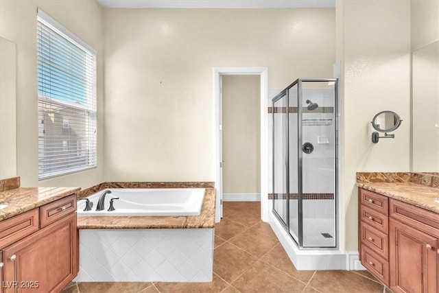 bathroom featuring plus walk in shower, vanity, and tile patterned floors