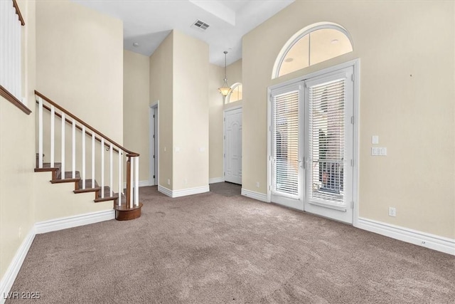 carpeted entrance foyer featuring a high ceiling