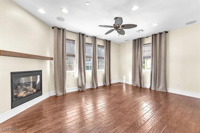 unfurnished living room with dark wood-type flooring and ceiling fan