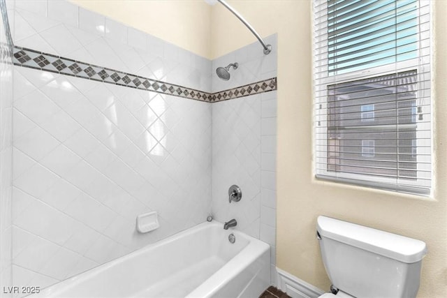 bathroom featuring toilet and tiled shower / bath combo