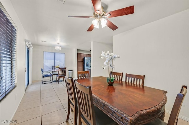 dining space featuring ceiling fan, light tile patterned flooring, visible vents, and baseboards