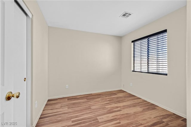 unfurnished room with baseboards, visible vents, and light wood-style floors