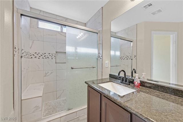 full bath featuring a stall shower, vanity, and visible vents