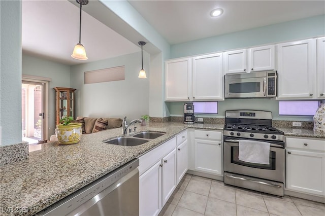 kitchen featuring white cabinetry, stainless steel appliances, decorative light fixtures, and sink