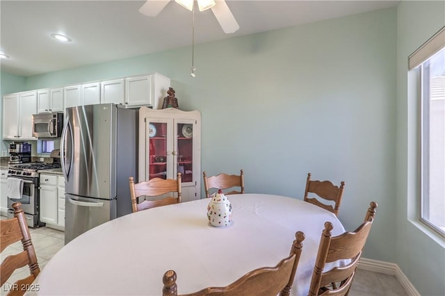 dining space with light tile patterned floors and ceiling fan