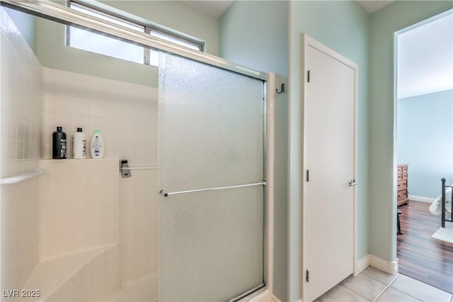 bathroom with an enclosed shower and tile patterned floors